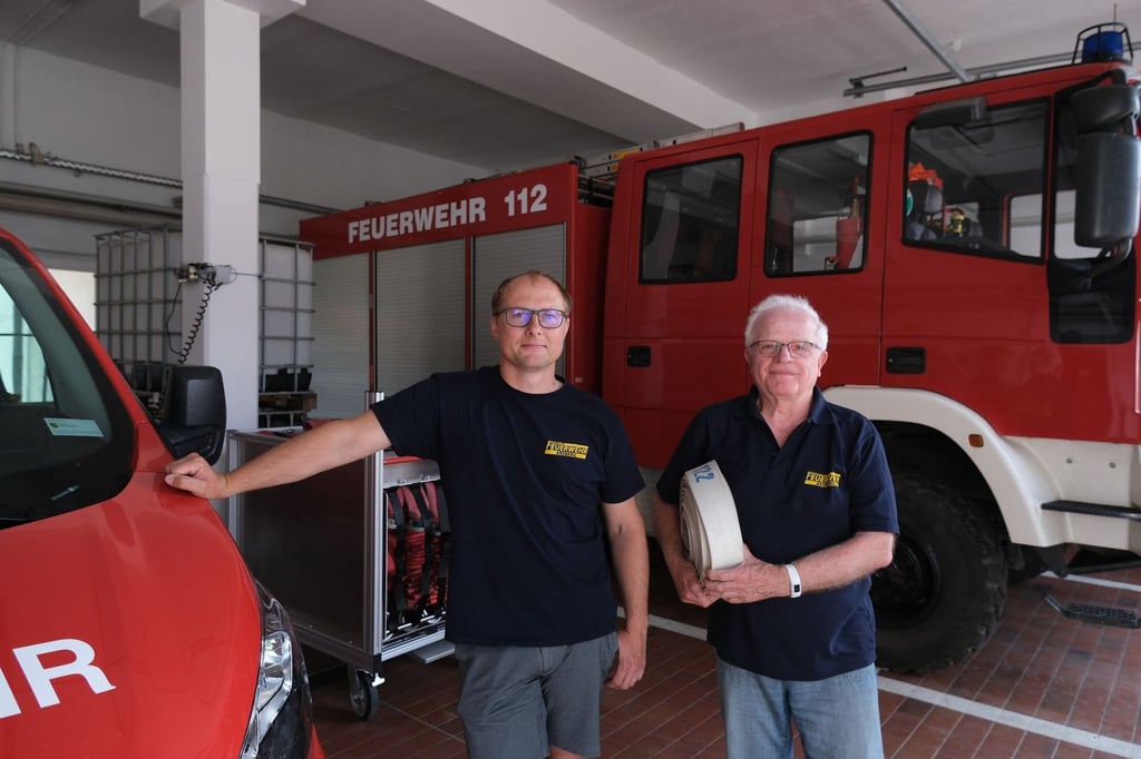Christian Rothe (l) und Klaus Grabein, Mitglieder der Freiwilligen Feuerwehr, stehen im Gerätehaus.