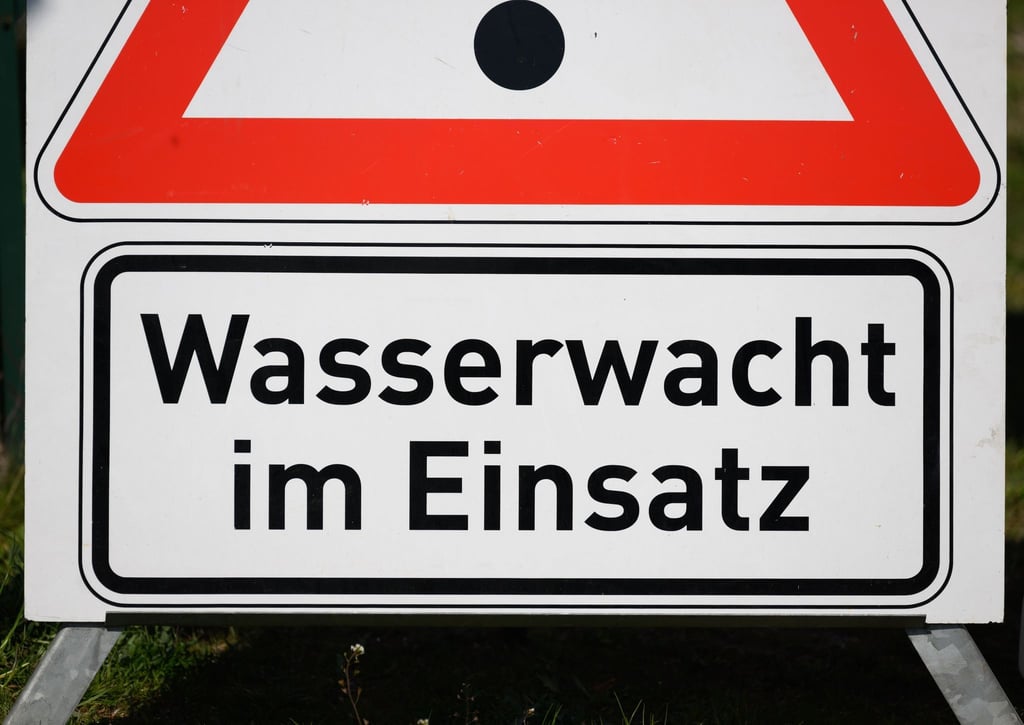 Ein Schild „Wasserwacht im Einsatz“ steht am Rande der offiziellen Übergabe von neuen Motorbooten am Bärwalder See.