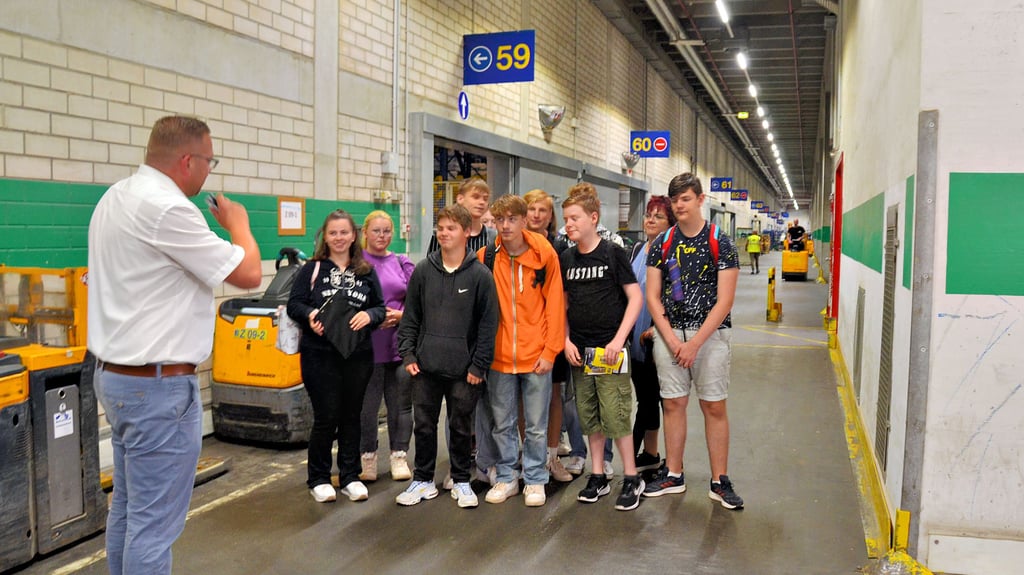 Der Leiter der Ausbildung bei Edeka in Osterweddingen, Mario Wehr, führt die Klasse 8b der Sekundarschule „Wilhelm Weitling" am ersten Ausbildungstag durchs Lager.