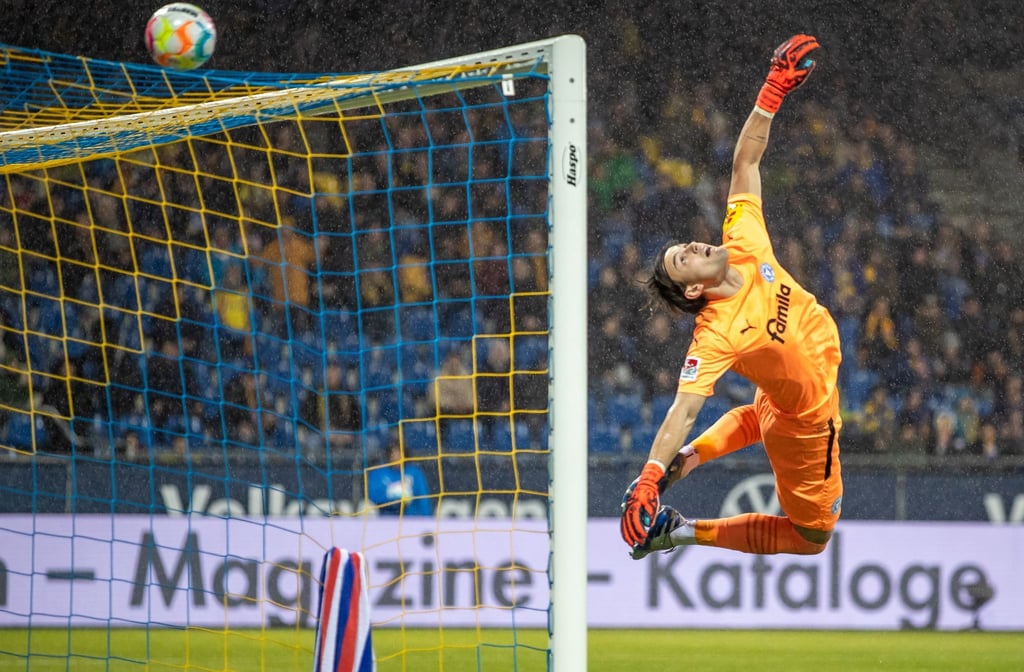 Torwart Tim Schreiber von Holstein Kiel pariert einen Ball über das Tor.