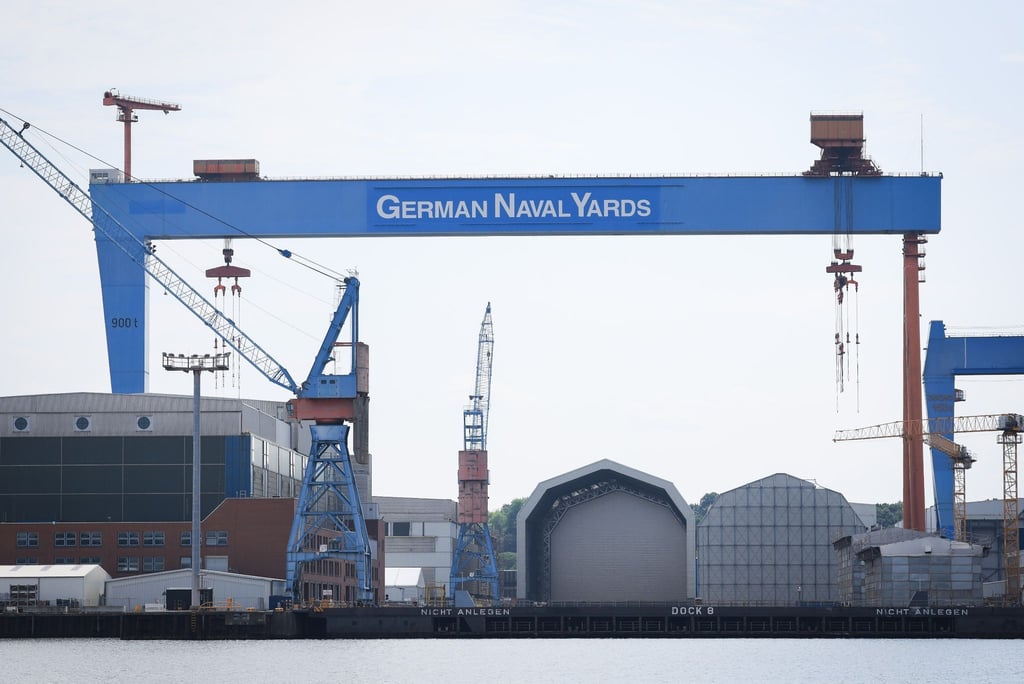 Zwei Kräne und mehrere Werfthallen auf dem Gelände der Werft Thyssenkrupp Marine Systems (TKMS) und German Naval Yards Kiel GmbH im Hafen von Kiel.
