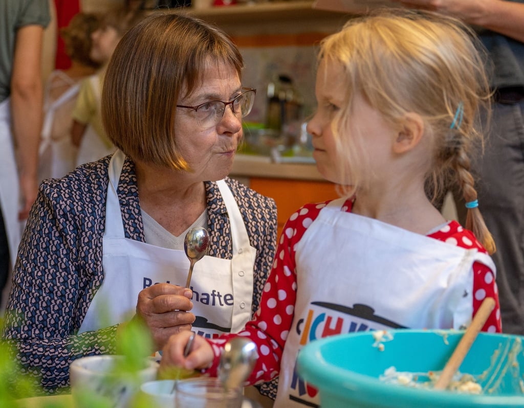Ursula Nonnemacher (Bündnis 90/Die Grünen), Gesundheitsministerin von Brandenburg, kocht mit einem Mädchen.