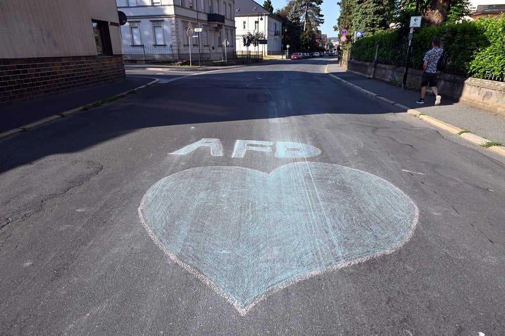 Ein blaues Herz und der Schriftzug AfD sind mit Kreide auf eine Straße in Sonneberg gemalt.
