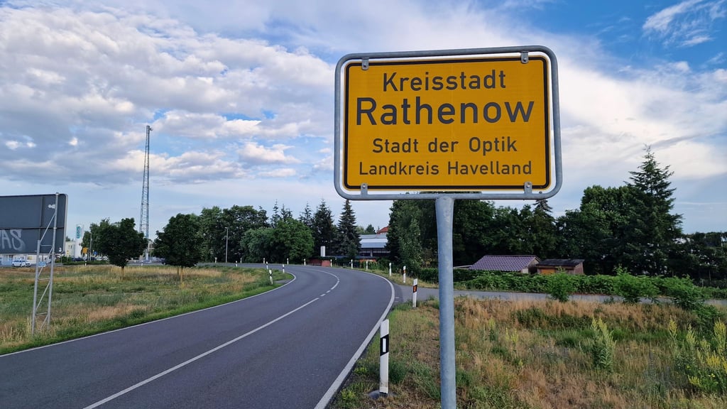 Das Ortsschild von Rathenow ist an einer Straße zu sehen.