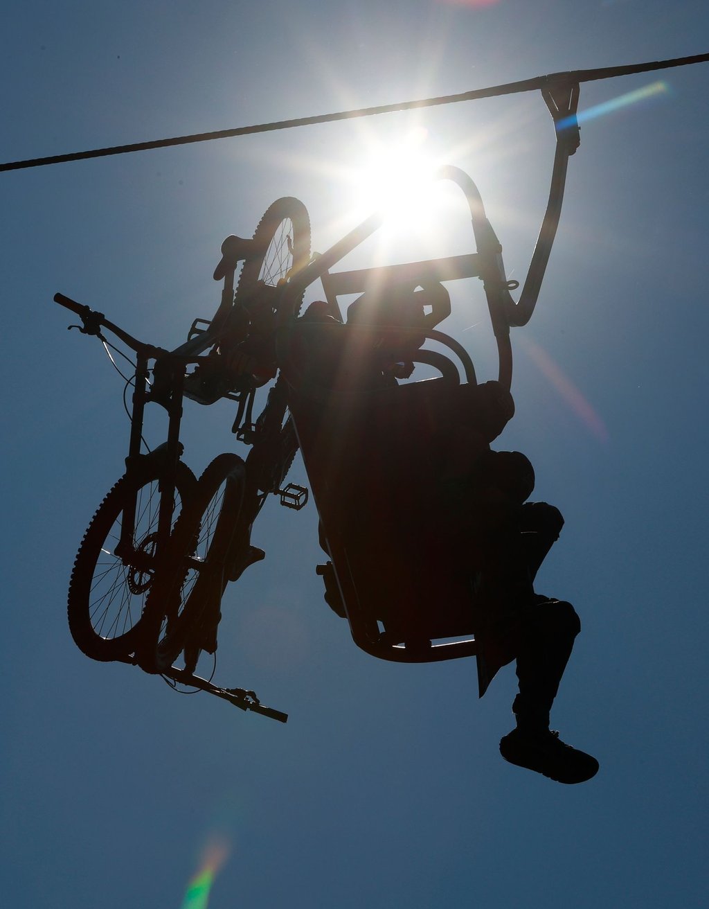 Radfahrer sitzen im Sessellift und fahren zur Rosstrappe hinauf.