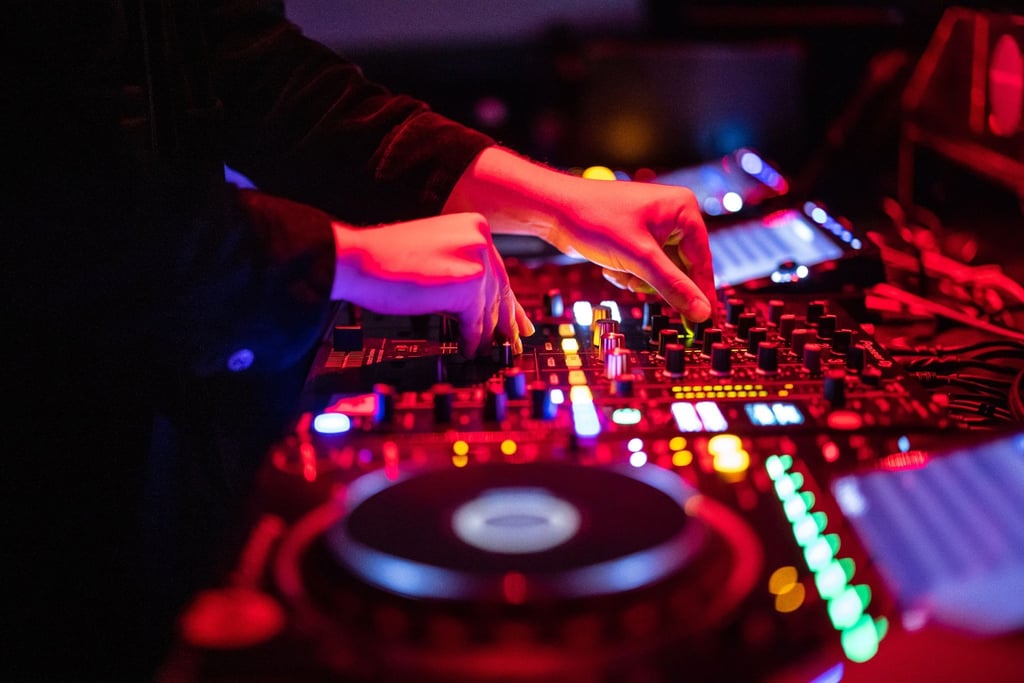 Ein DJ steht am Mischpult.