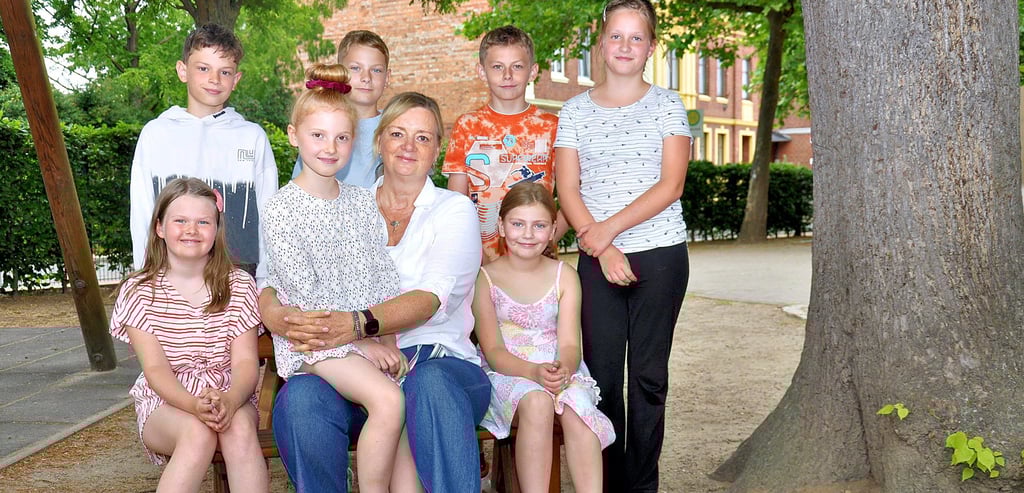 Katrin Lehmann mit mehreren Dritt- und Viertklässlern auf dem Pausenhof der Grundschule am Hain.