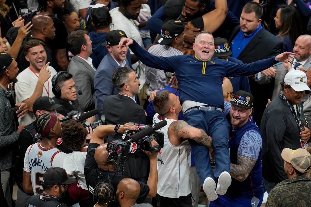 Michael Malone, Cheftrainer der Denver Nuggets, wird von den Fans hochgehoben, nachdem das Team die NBA-Meisterschaft gewonnen hat.