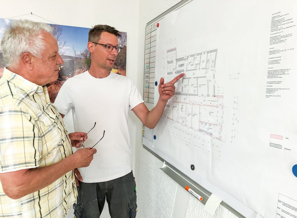 Firmengründer Ehrhard Bahr (l.) und Sebastian Bahr, Geschäftsführer der LB Bau GmbH, an den Plänen für ein Bauprojekt, an dessen Umsetzung das Unternehmen beteiligt war.