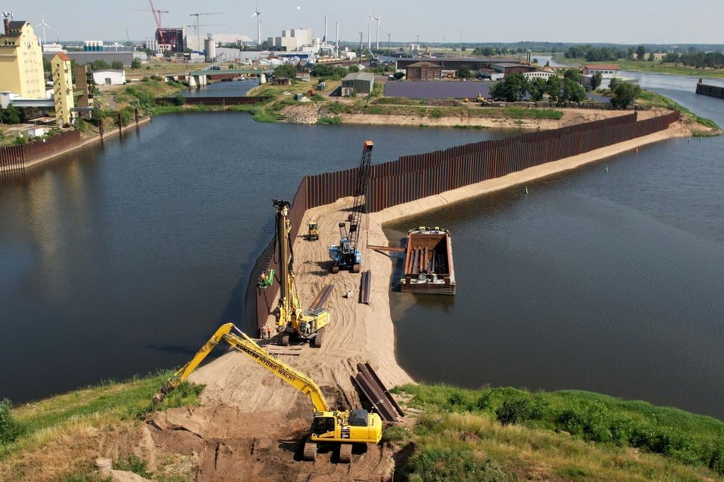 Mit Baggern und Schuten wird am neuen Damm im Industriehafen Magdeburg gearbeitet.