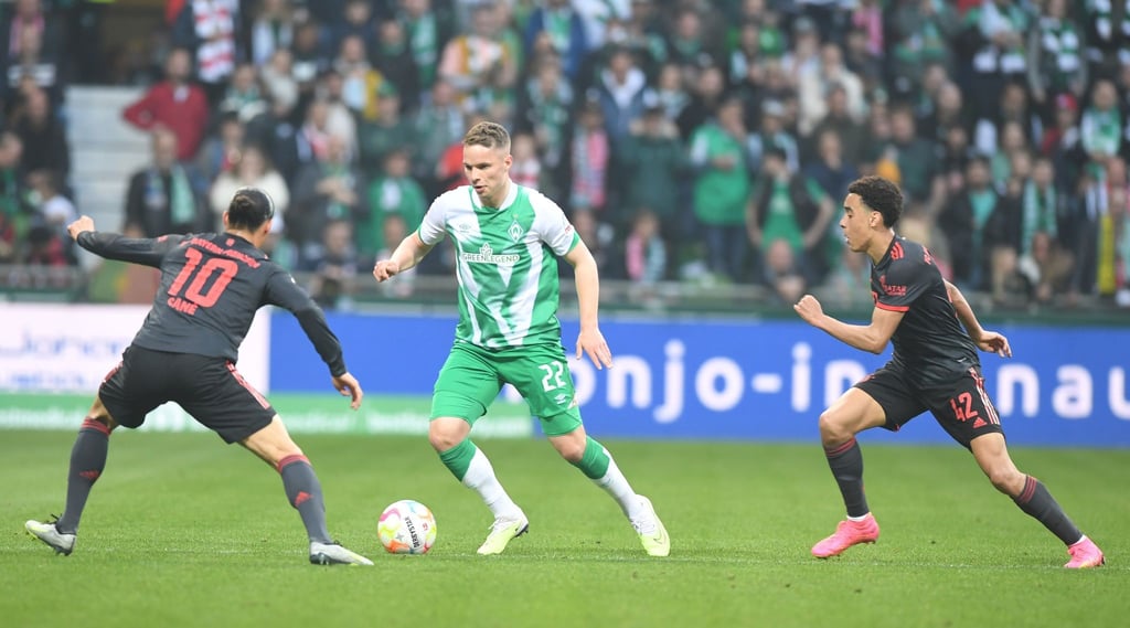 Werders Niklas Schmidt (M) kämpft gegen Bayerns Leroy Sane (l) und Jamal Musiala um den Ball.
