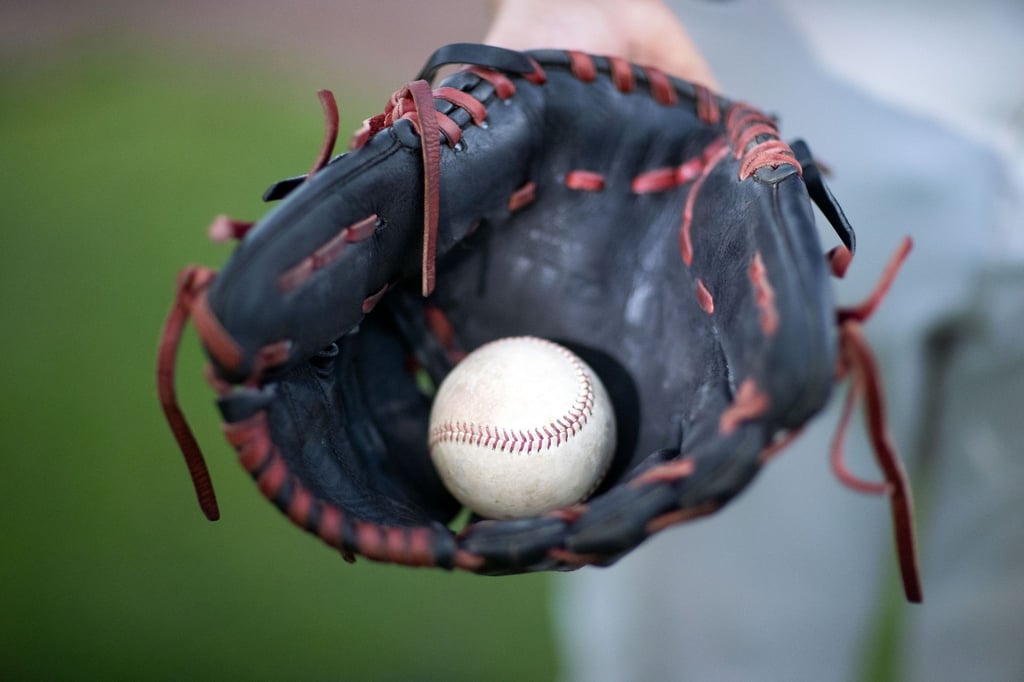 Ein Baseball liegt in einem Fanghandschuh.