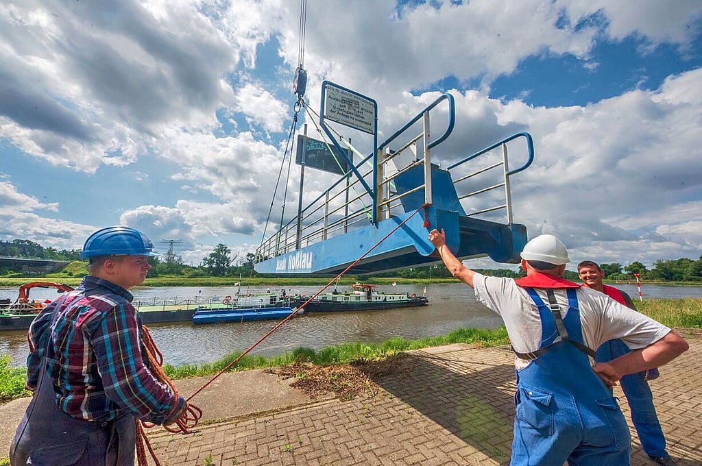 Der sperrige Laufsteg wird zu Wasser gelassen und aufwendig und fest vertäut.