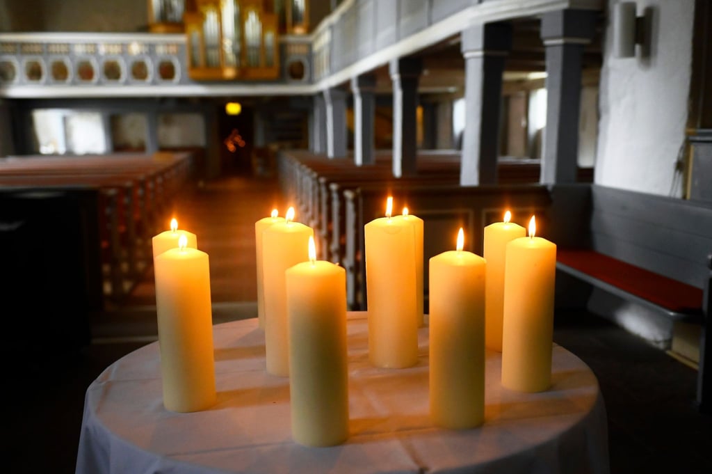 Zehn Kerzen für Beteiligte und Opfer stehen auf einem Tisch vor dem Altar in der St. Johannis Kirche.
