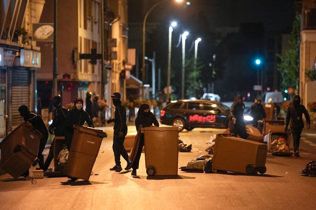 Protestierende blockieren eine Straße mit Mülleimern in Colombes, außerhalb von Paris.