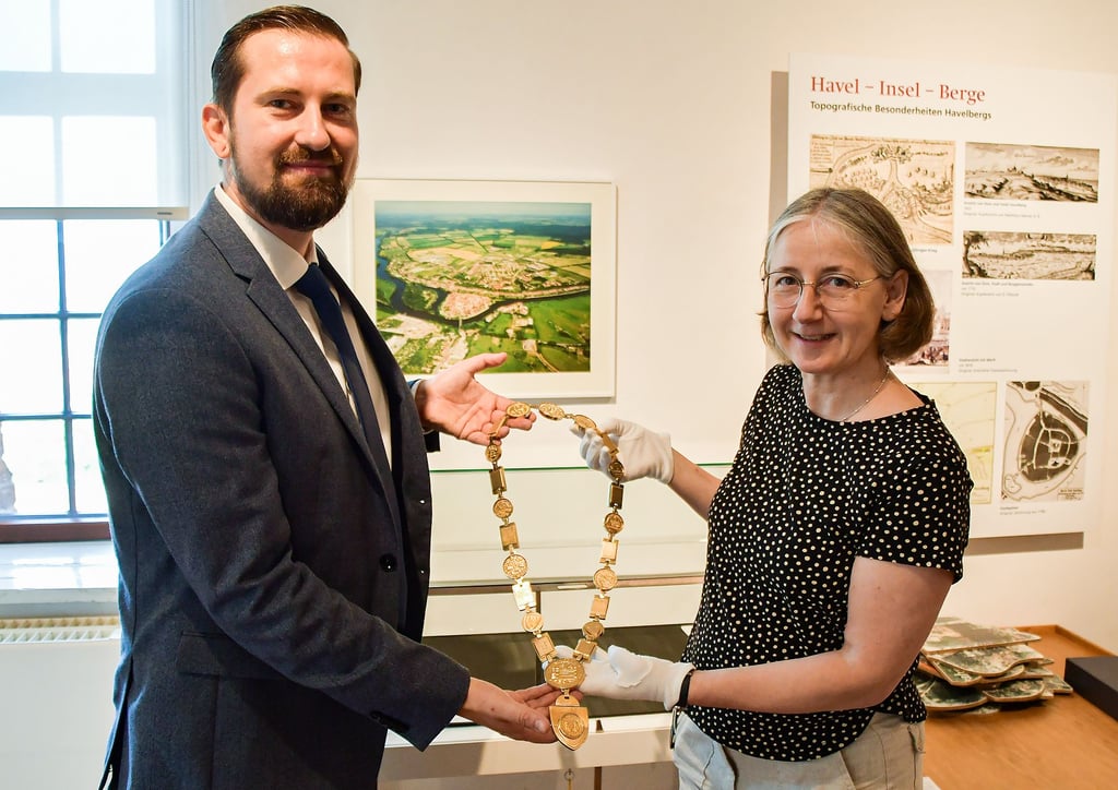 Bürgermeister Mathias Bölt übergibt der Leiterin des Prignitz-Museums Havelberg, Antje Reichel, die Amtskette als Leihgabe. Dort ist sie in der Ausstellung zur Stadtgeschichte zu sehen.