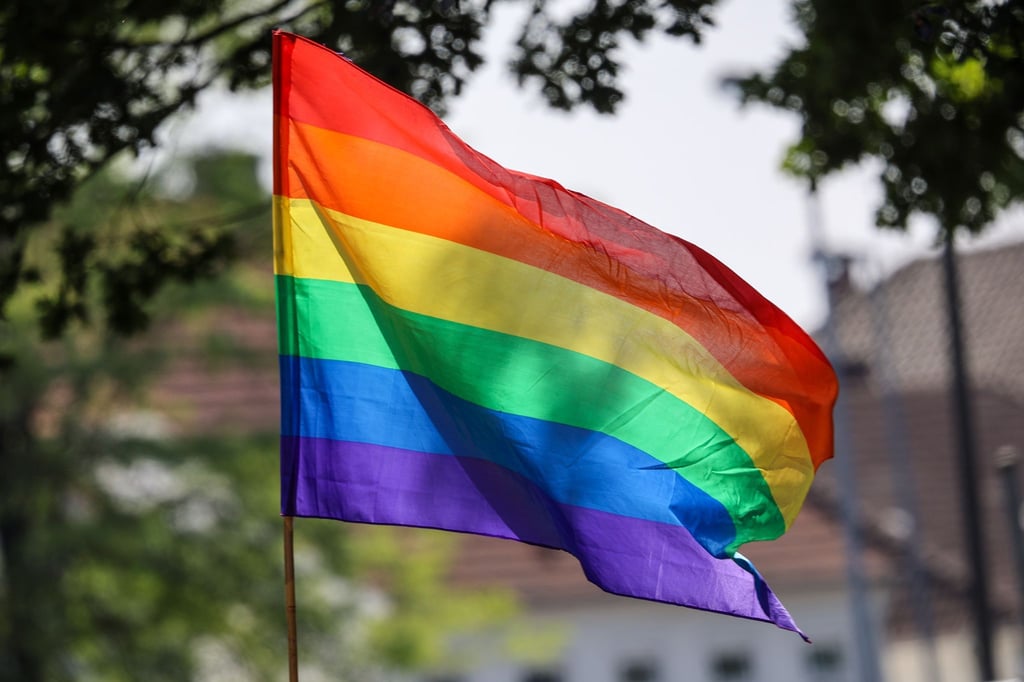Eine Regenbogenfahne weht im Wind.