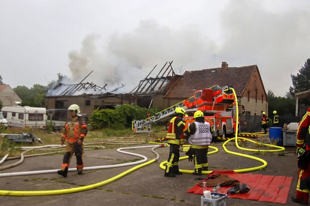 Einsatzkräfte der Feuerwehr löschen eine brennende Scheune.