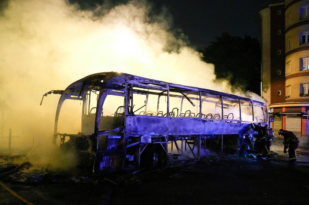 Rauch steigt bei nächtlichen Krawallen aus einem ausgebrannten Bus in Nanterre.