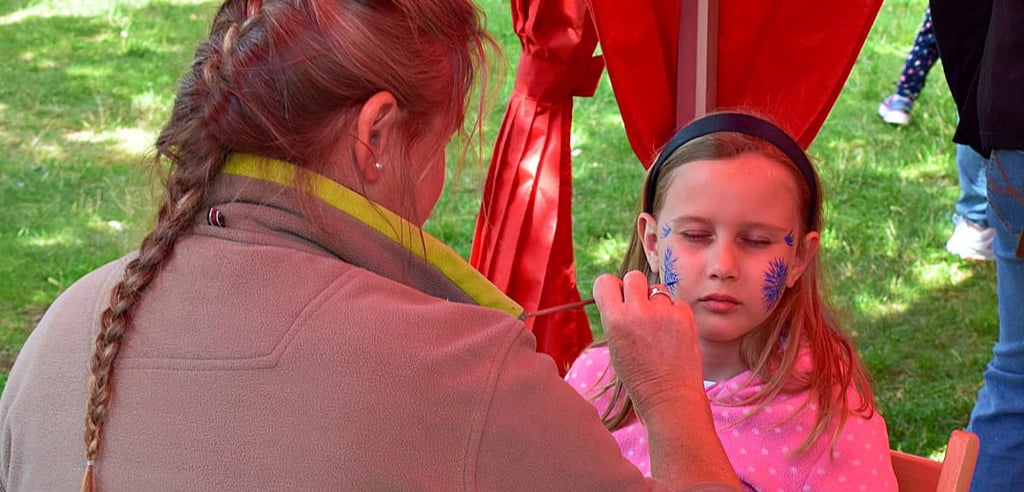 Amilia Claudia Weidlich aus Aschersleben wird beim Kinderfest im Bürgerpark Wernigerode von Stefanie Klemenz geschminkt.