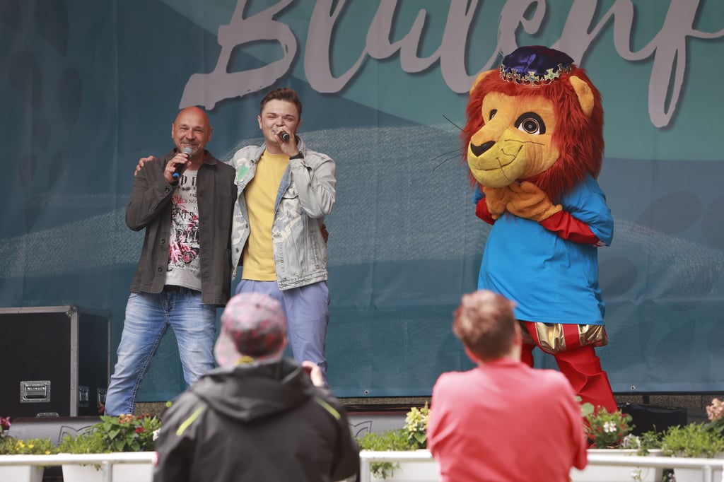 Moderator René Tippmann mit Schlagersänger Kevin Neon und Maskottchen Welfie.