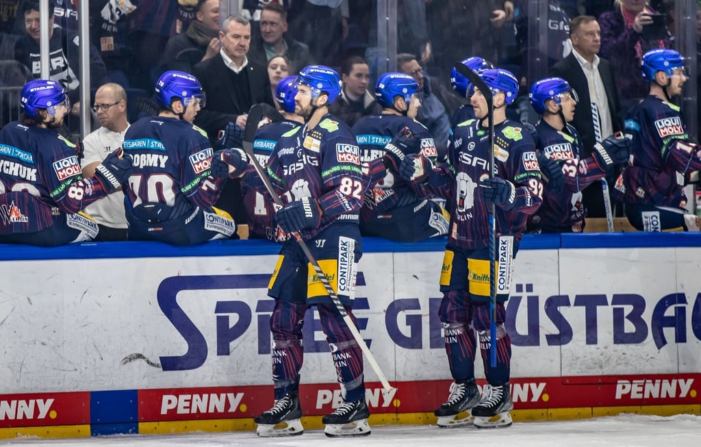 Berlins Alexandre Grenier (l) und Marcel Noebels klatschen mit Teamkollegen ab.