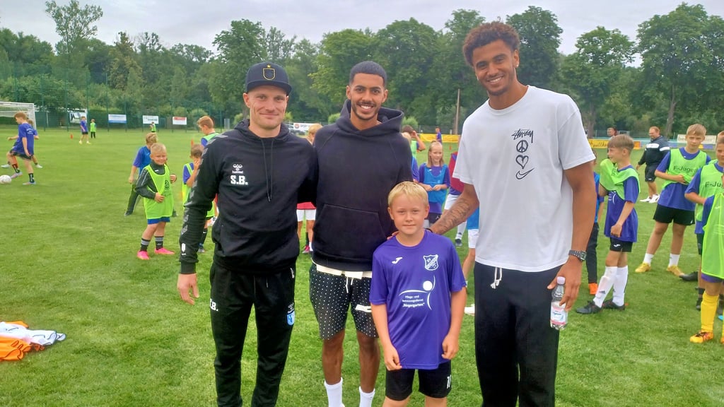 Magdeburgs Co-Trainer Silvio Bankert (von links) sowie die FCM-Profis Tarek Chahed und Jamie Lawrence mit dem Plötzkauer Nachwuchskicker Basti Heinemann.