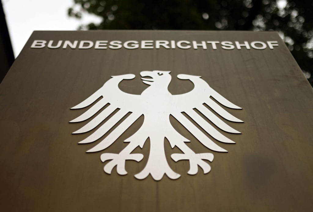 Ein Hinweisschild mit dem Bundesadler steht vor dem Bundesgerichtshof (BGH) in Karlsruhe.