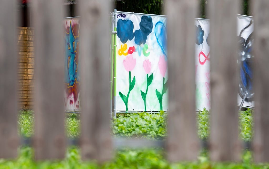 Am Rand einer Brachfläche hängen von Kindern gestaltete Plakate an Bauzäunen. An dieser Stelle stand das Haus, vor dem der Messerangriff auf zwei Schülerinnen stattfand.