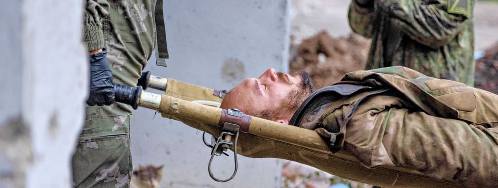 Ein verletzter Soldat wird im Kriegsgebiet in der Ukraine auf einer Trage abtransportiert. Viele der Verwundeten, sowohl Zivilisten als auch Soldaten, hat Deutschland seit Kriegsbeginn aufgenommen und behandelt.
