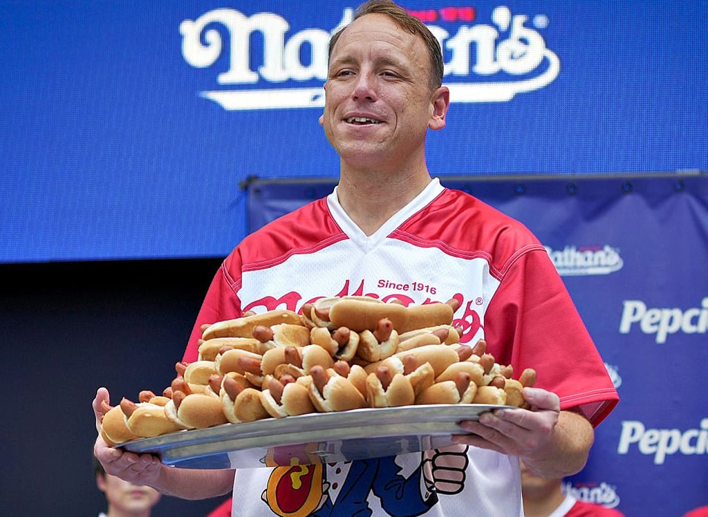 Wettkampfesser Joey Chestnut hat einen guten Appetit: Hier zeigt er einen Teller mit 76 Hotdogs – sein aktueller Weltrekord.