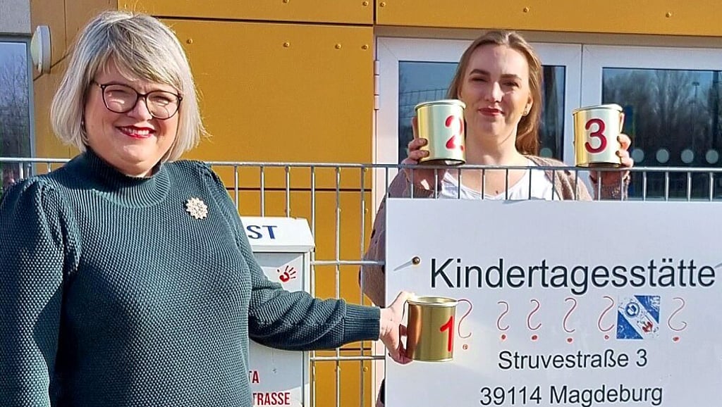Große Fragezeichen stehen hier noch auf dem Schild am Zaun der Kita „Struvestraße“ in Magdeburg-Cracau. Doch das soll sich bald ändern. Ein, zwei oder drei? Ina Henkel und Isabell Blume zeigen hier noch namenlose Dosen. Jetzt aber stehen drei Favoriten zur Auswahl.