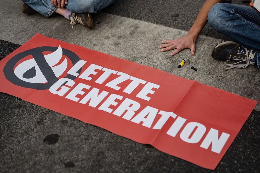 Ein Aktivist der Gruppe „Letzte Generation“ blockiert eine Kreuzung.