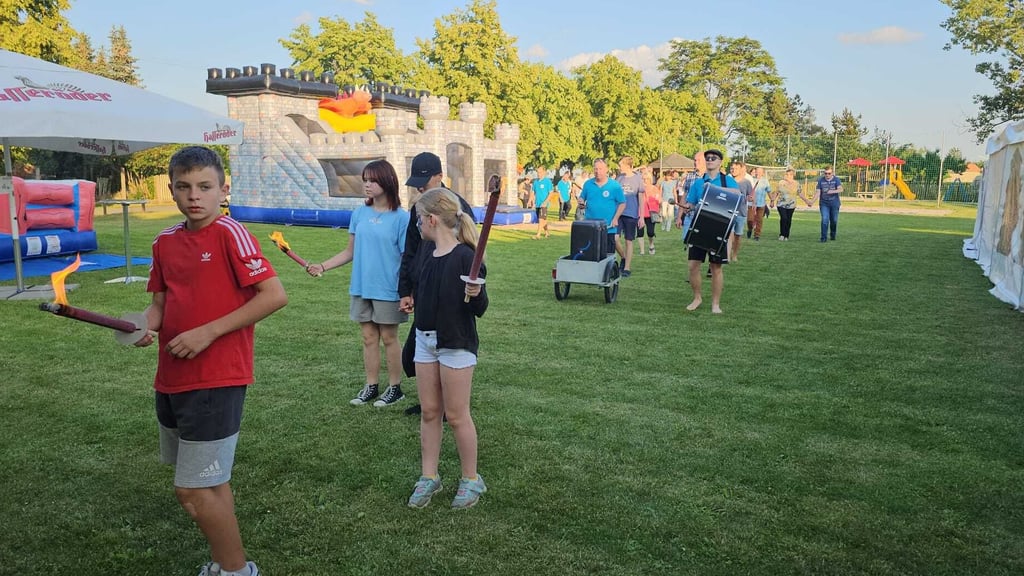 Der Festumzug hat den Festplatz in Bethau erreicht. Hinter den Fackeln läuft der Zweimann-Spielmanszug.