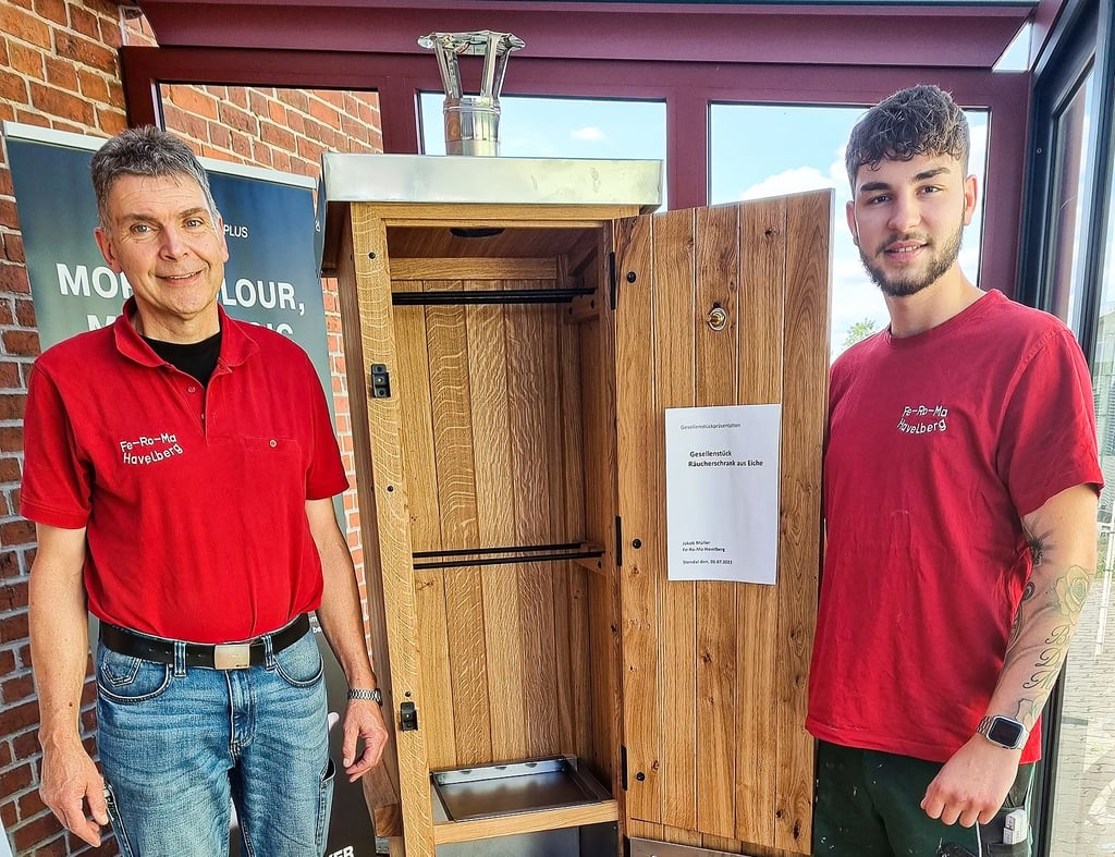 JörgMüller (links) und Jakob Müller mit dem Gesellenstück: einem Räucherschrank. Dieser ist derzeit bei FeRoMa in der Pritzwalker Straße in Havelberg ausgestellt.