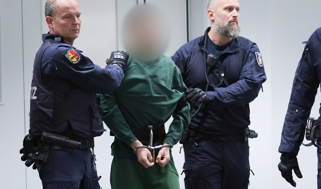 Der Angeklagte Ibrahim A. wird von Justizbeamten an seinen Platz im Gerichtssaal gebracht.