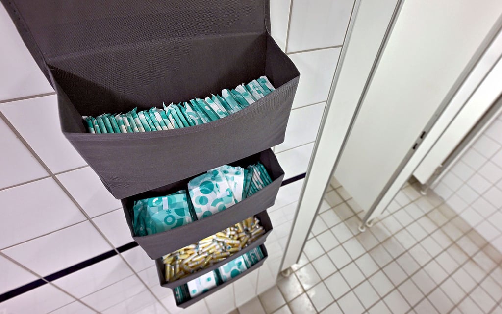 Periodenprodukte liegen in einer Toilette. An den kommunalen Schulen in Magdeburg soll es zukünftig gratis Binden und Tampons in den Toilettenräumen geben.