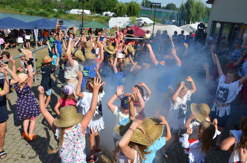 Ausgelassen kommen die Nachwuchs-Feuerwehren nach dem Supertalent-Finale mit dem "Zug ohne Bremsen" ins Rollen. Als Erinnerung an das Zeltlager 2023 am Güstener Kiesschacht bleiben den insgesamt 600 Teilnehmern auch Strohhüte und Bändchen.