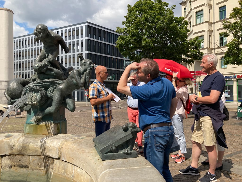 Viel Sehenswertes: Touristen mit Stadtführer auf Halles Hallmarkt