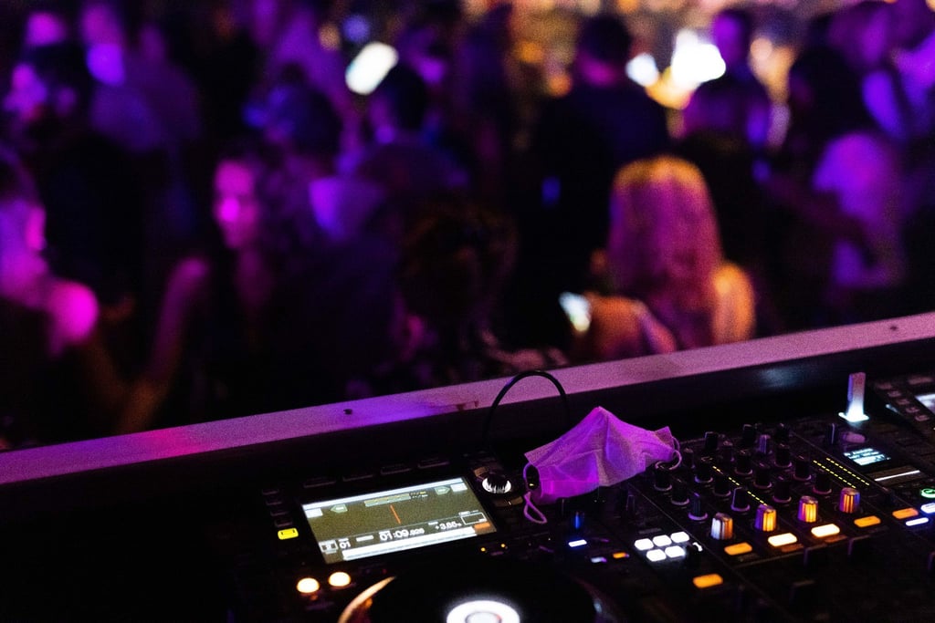 Eine Maske liegt in einem Club auf dem Mischpult.