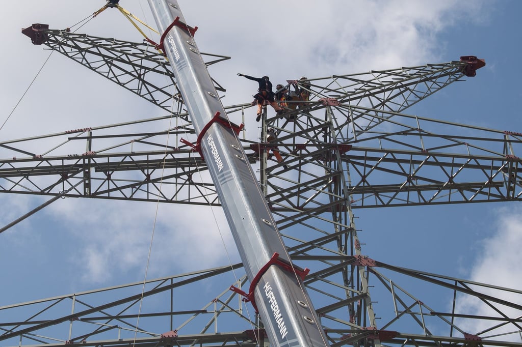 Arbeiter bauen Masten für Hochspannungsleitungen auf einer Tennet-Baustelle.