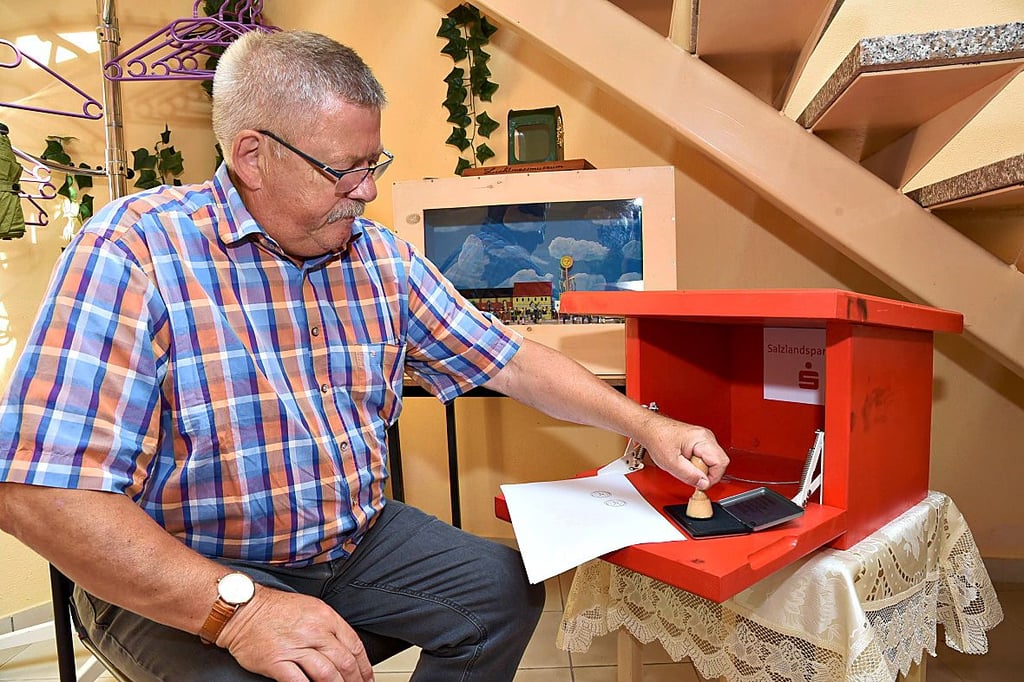 Im Lichtmessmuseum Glinde testet Ortsbürgermeister Norbert Langoff die frische Stempelfarbe.