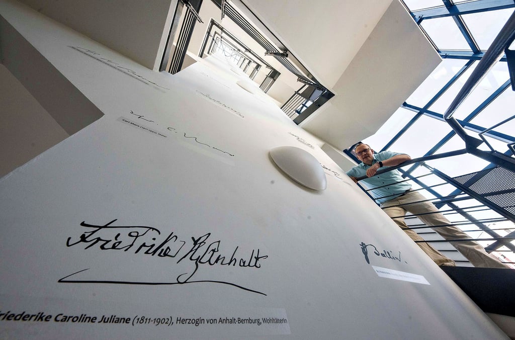 Landesarchiv Wasserturm Heidestraße. Blick in die Jubiläumsausgabe und die Autographensammlung wichtiger Anhalter im Treppenhaus