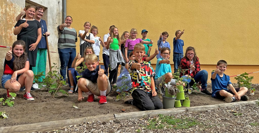 Sandra Cymander (4.v.l.) schenkte der Grundschule Niegripp 25 Pflanzen, die in einer bisher ungenutzten Ecke ein neues Zuhause gefunden haben.