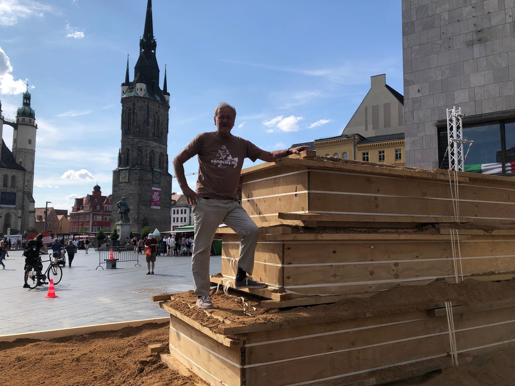 Halle am Meer: Benno Lindel (im Bild) und Jan Zelinka wollen aus 40 Tonnen Sand eine Strandlandschaft auf Halles Markt gestalten. Zuvor aber muss der angelieferte Sand nach dem Anfeuchten in feste Formen gepresst werden, damit er mit verschiedenen Werkzeugen bearbeitet werden kann.