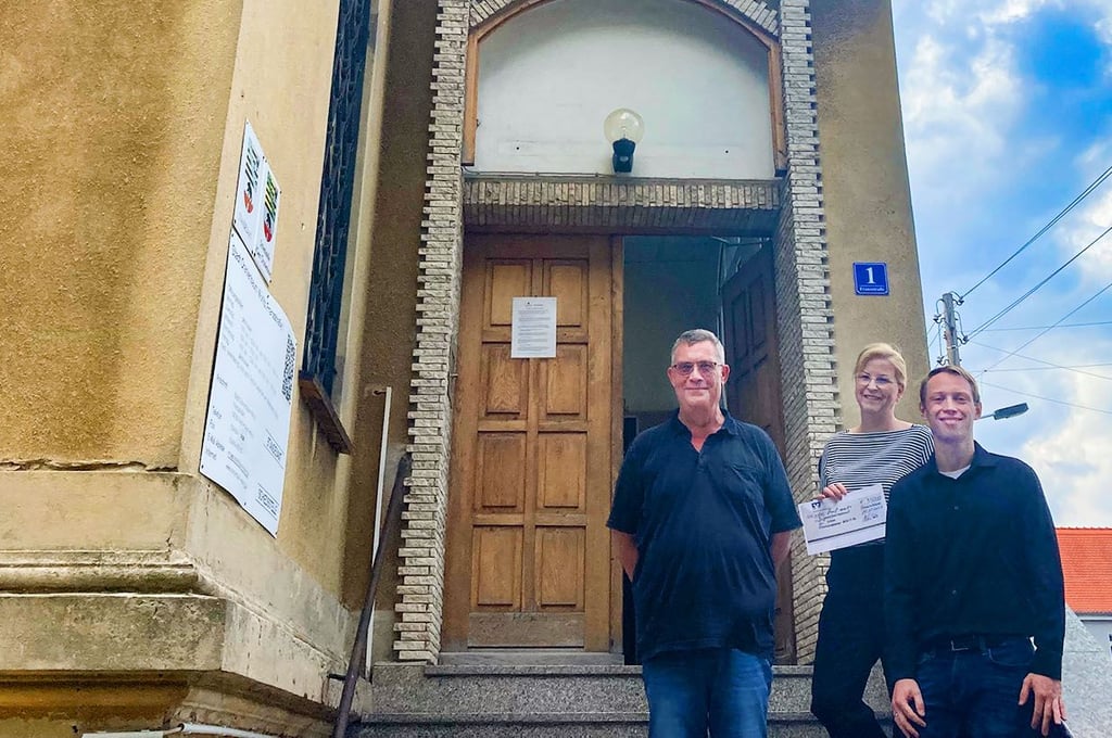 Silke Hövelmann von der Volksbank Dessau-Anhalt zur Spendenscheckübergabe am Rathaus von Oranienbaum, mit Roland Seebert (l.) und Jan Illmer