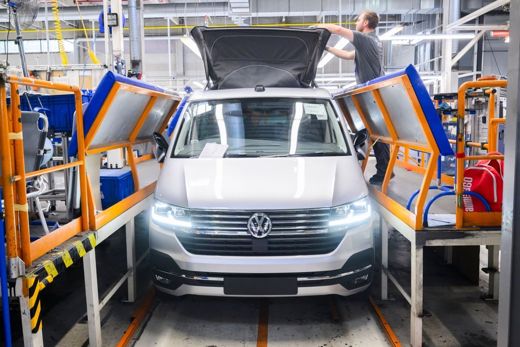 VW Mitarbeiter montieren das Dach von einem Reisemobil Volkswagen California in Hannover.