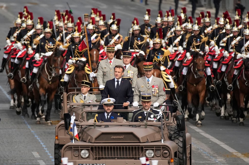 Frankreichs Präsident Emmanuel Macron in einem Kommandowagen mit General Thierry Burkhard, Chef des Generalstabes, bei der Parade auf der Avenue des Champs-Élysées. Frankreich erinnert an den Sturm auf die Bastille im Jahr 1789, der als symbolischer Beginn der Französischen Revolution angesehen wird.