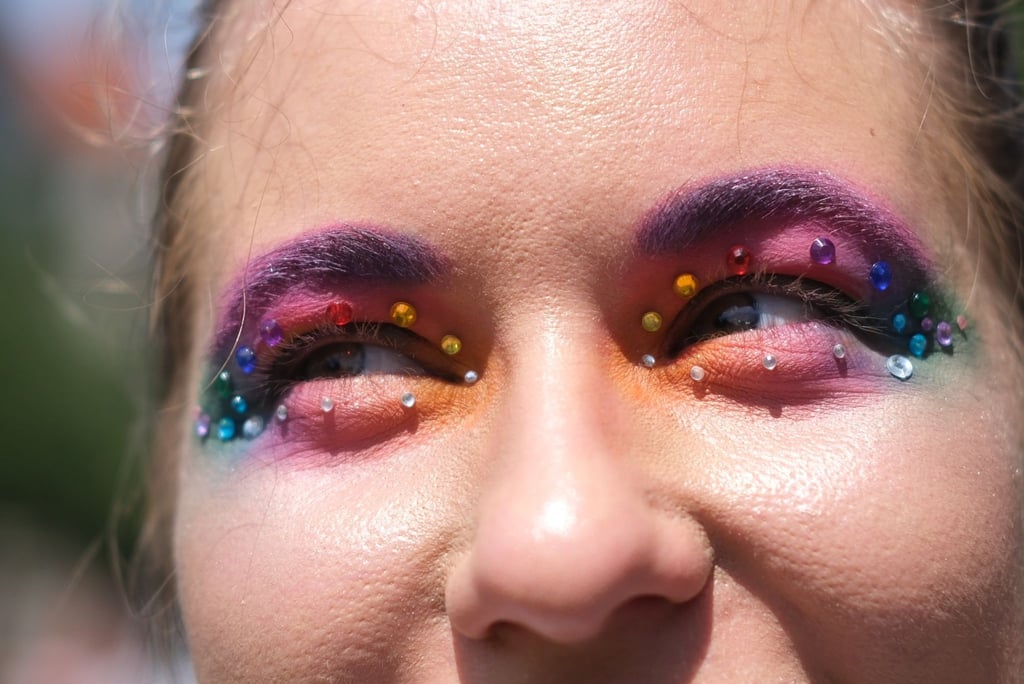 Eine in den Farben des Regenbogens geschminkte Teilnehmerin der Demonstration zum CSD.