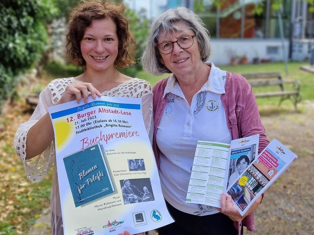 Maria Sonnabend und Stefanie Obieglo zeigen die Plakate für die Altstadtlesenacht in Burg.